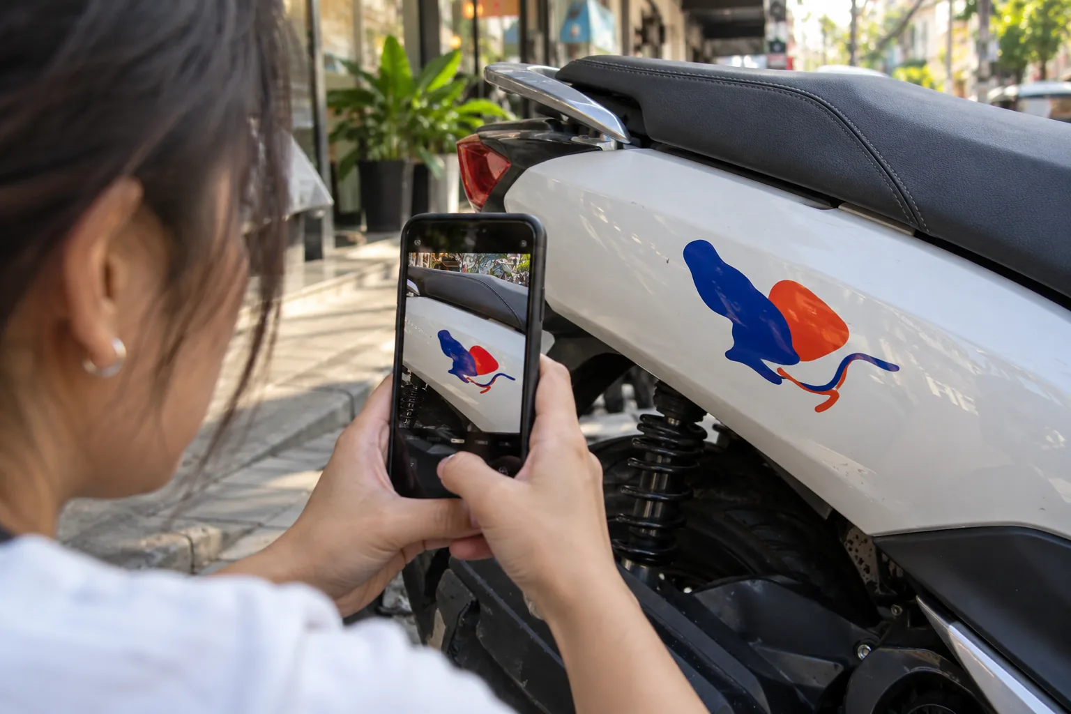 Host photographing a small decal on their motorbike